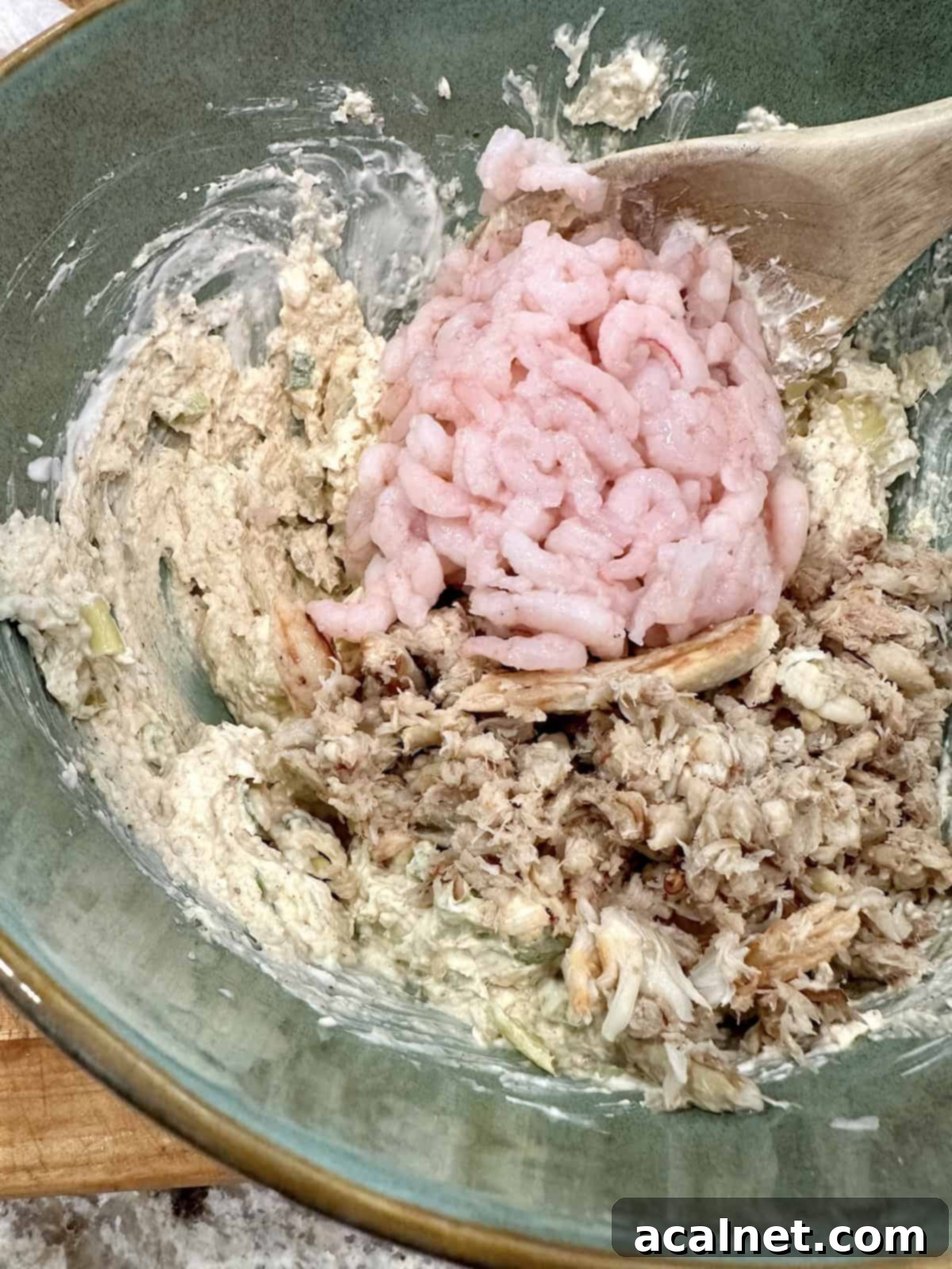 Irresistible Crab and Shrimp Dip 11 Shrimp and crab are gently folded into the creamy dip mixture in a bowl.