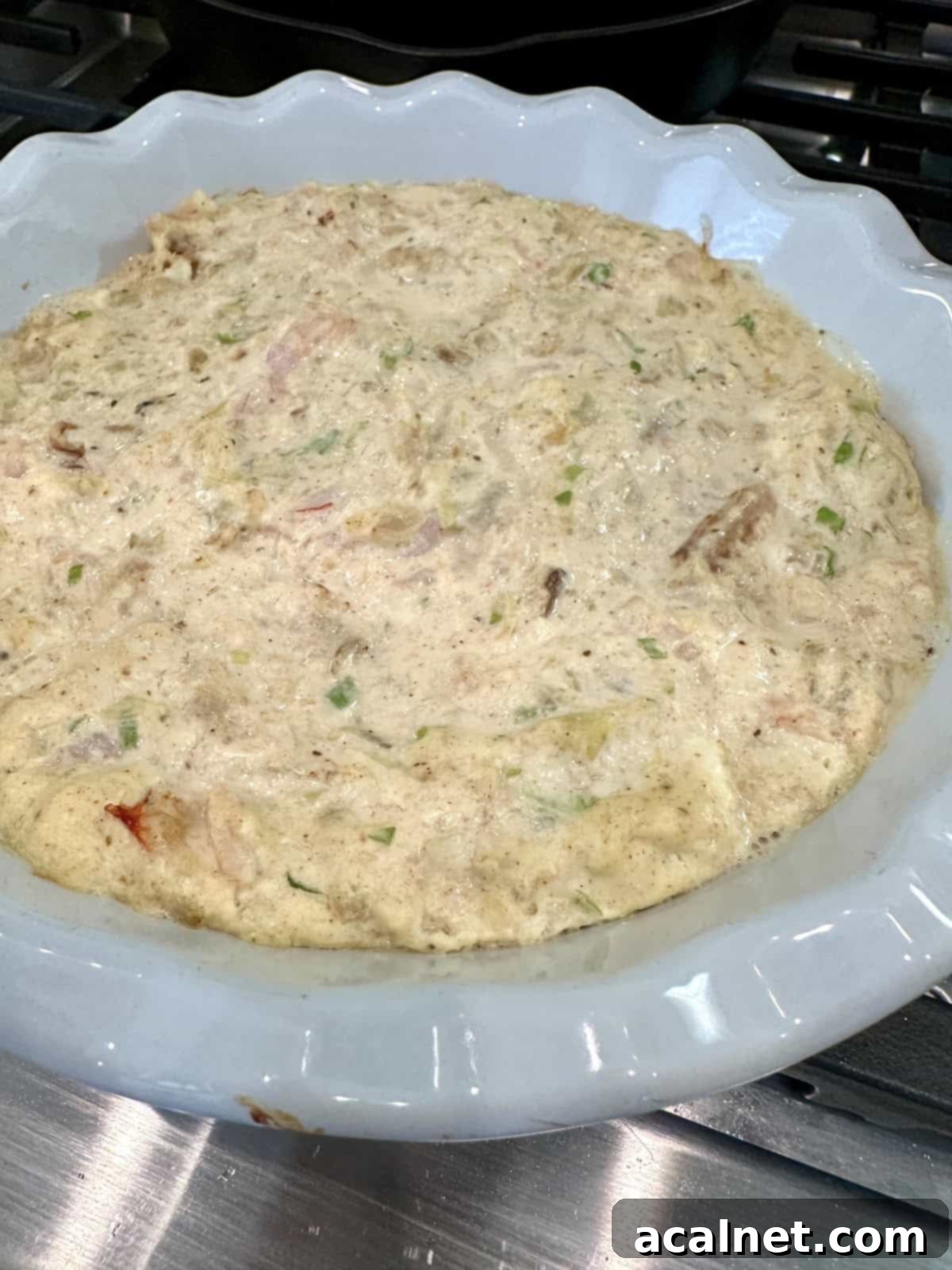 Irresistible Crab and Shrimp Dip 12 Shrimp and crab dip in a ceramic baking dish, ready to be baked.