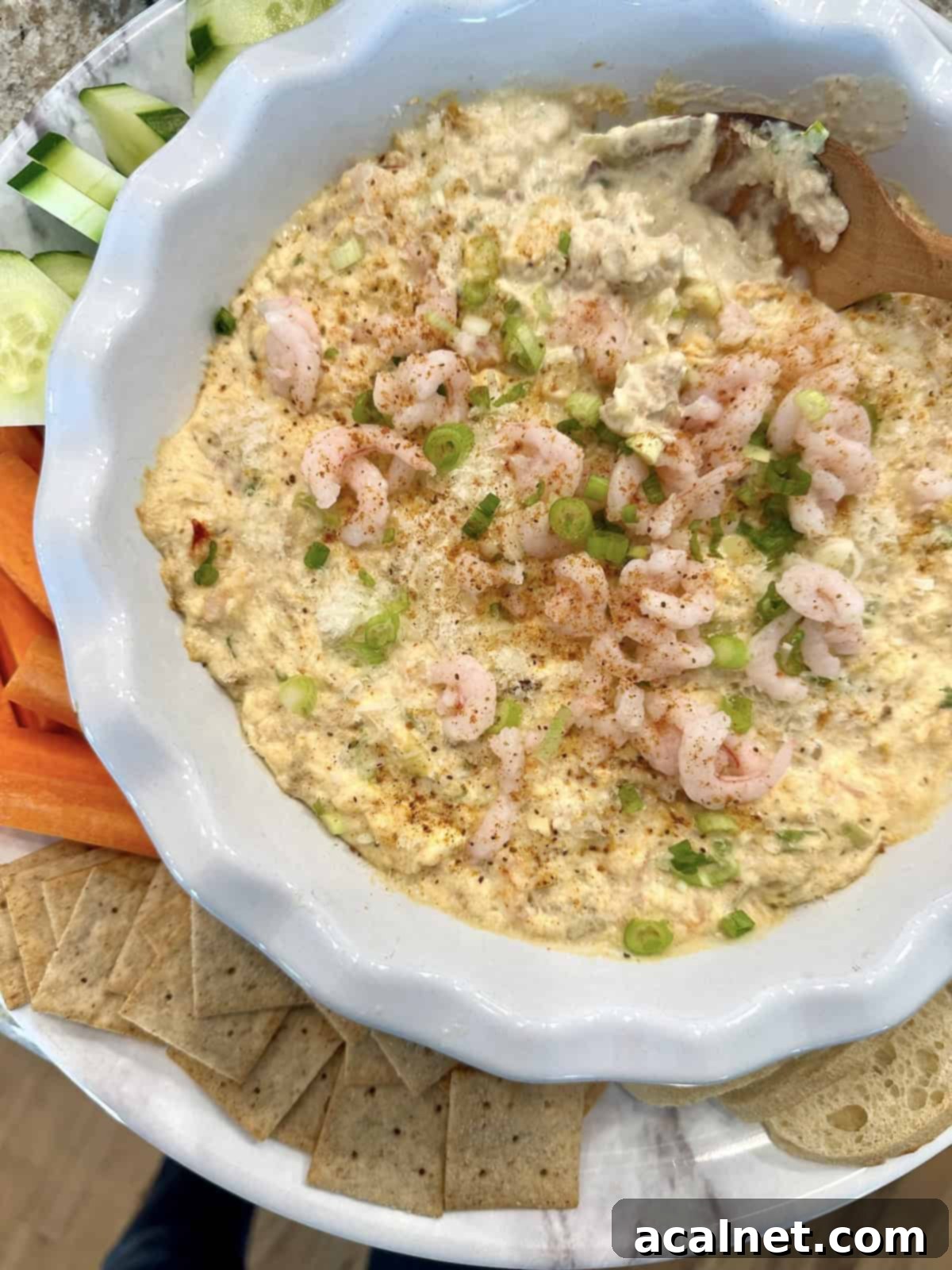 Irresistible Crab and Shrimp Dip 13 A beautifully arranged serving platter featuring a warm crab and shrimp dip with crackers, carrot sticks, and cucumber slices.
