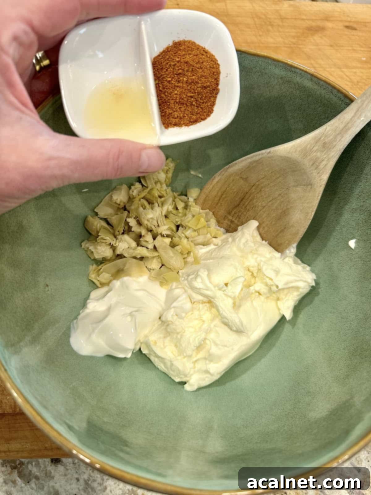 Irresistible Crab and Shrimp Dip 8 A bowl containing cream cheese, sour cream, green onions, and spices, before mixing in seafood.