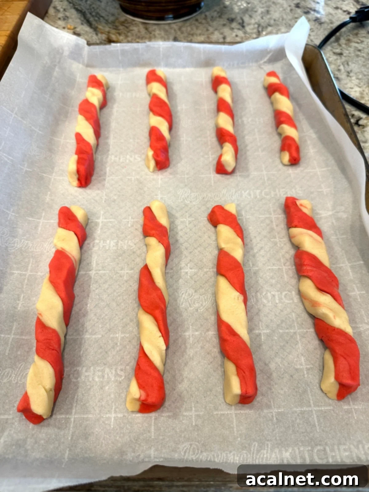 Candy cane cookies arranged on a baking sheet.