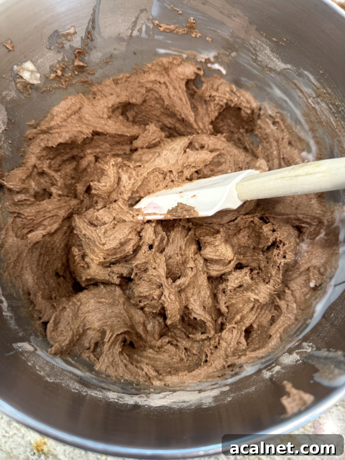 Chocolate zucchini cake batter partially mixed in a stand mixer, with buttermilk.