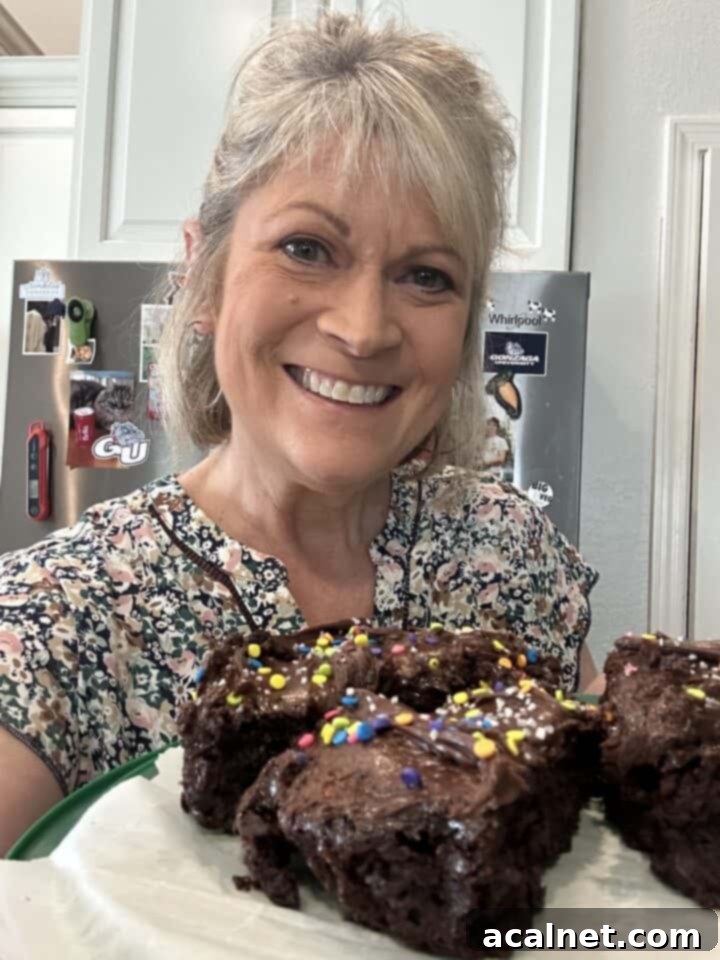 Melinda in the kitchen holding a plate of chocolate cake slices.