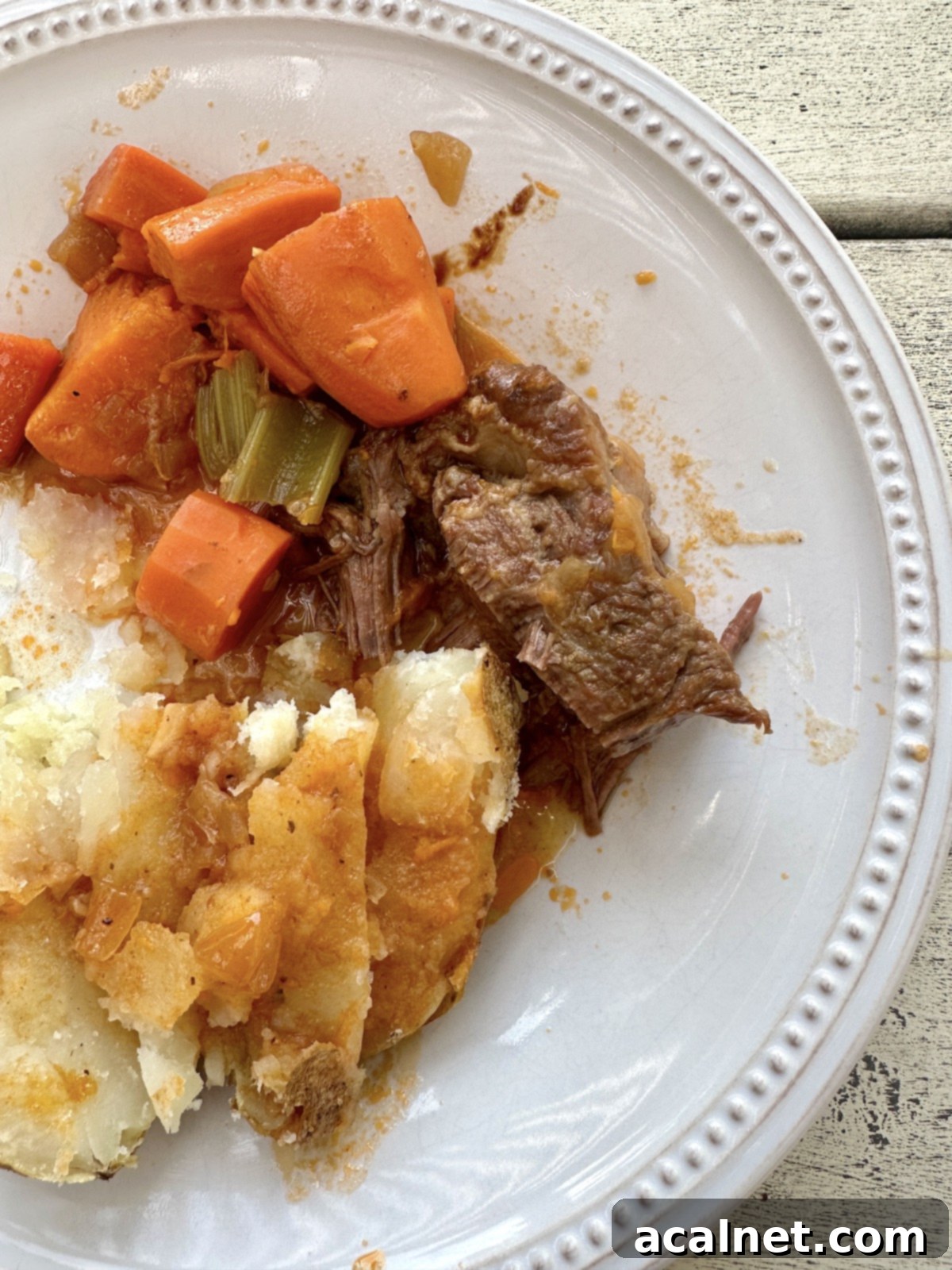 Dutch oven pot roast on a plate with vegetables.