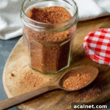 A jar of vibrant spice mix on a wooden cutting board, ready to infuse flavor.