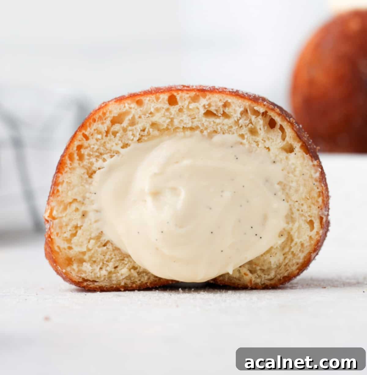 Gourmet Brioche Delights 9 A golden-brown brioche donut sliced in half, revealing a fluffy interior generously filled with a creamy delight.