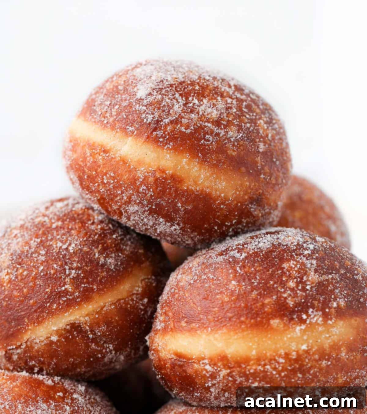 Gourmet Brioche Delights 10 Zoomed-in view of the golden-brown top of a stack of brioche donuts, highlighting their inviting texture and fresh appearance.
