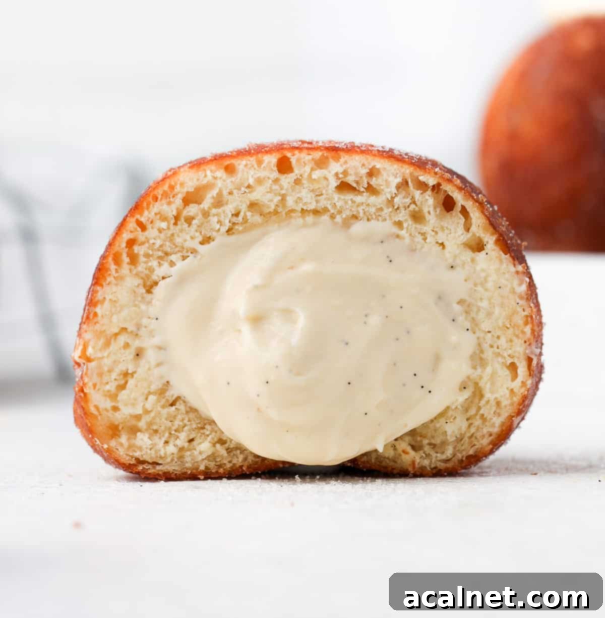 Decadent Bavarian Cream Doughnuts 10 Donut sliced in half with cream oozing out.