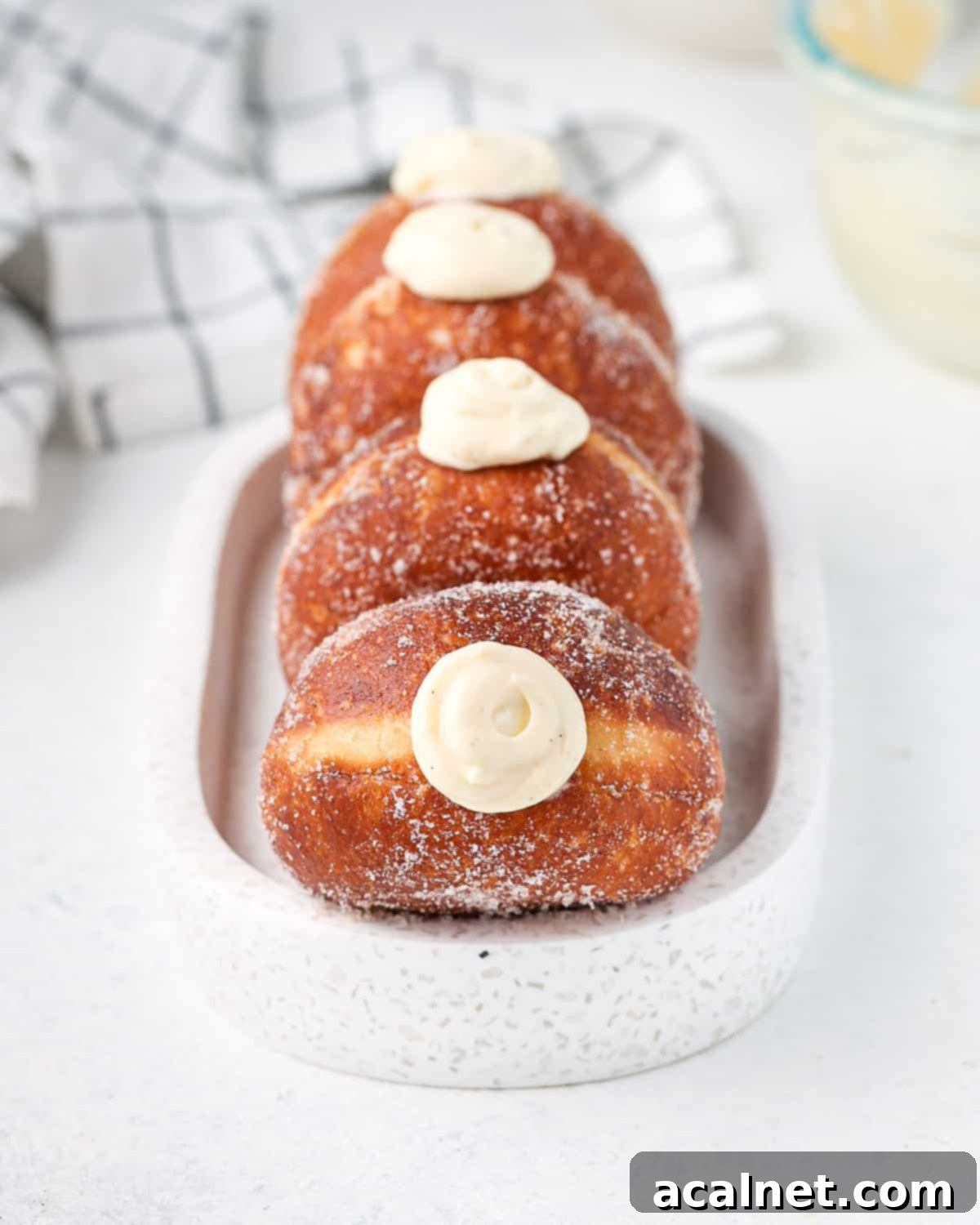 Decadent Bavarian Cream Doughnuts 9 Four donuts lined in an oval white dish.