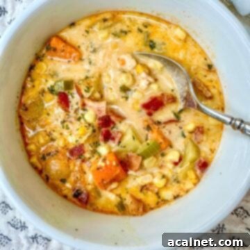 Golden Harvest Chowder 13 A close-up of a serving bowl filled with creamy corn and potato soup, garnished with crispy bacon and fresh parsley.