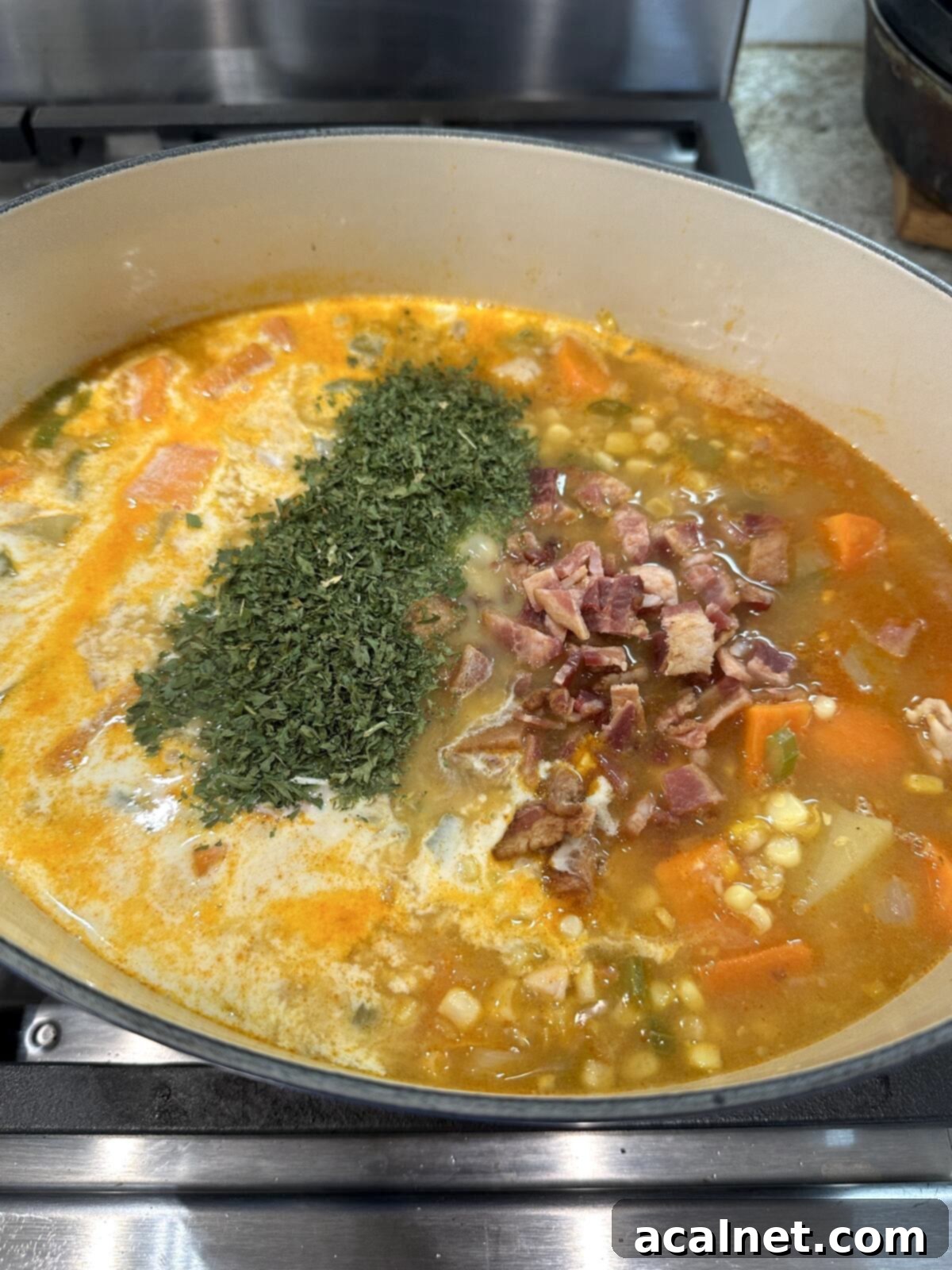 Golden Harvest Chowder 9 Cooked bacon crumbles, fresh parsley, and half-and-half being stirred into the finished corn and potato soup.