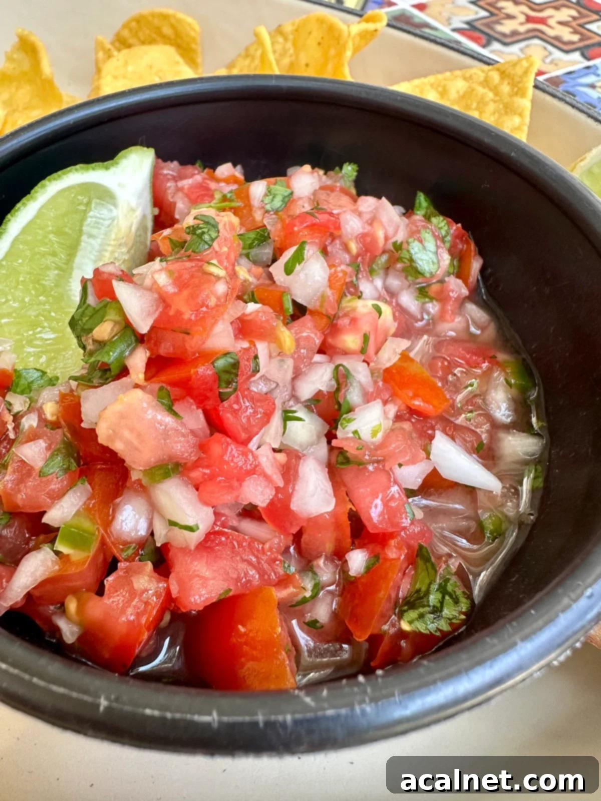 Zesty Jalapeño-Lime Pico de Gallo 12 A large, inviting bowl of fresh homemade pico de gallo, perfectly chunky and colorful, ready to be enjoyed with a stack of golden tortilla chips.