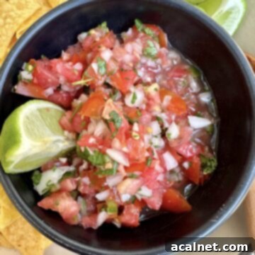 Zesty Jalapeño-Lime Pico de Gallo 13 Pico de gallo in a bowl with lime and tortilla chips.