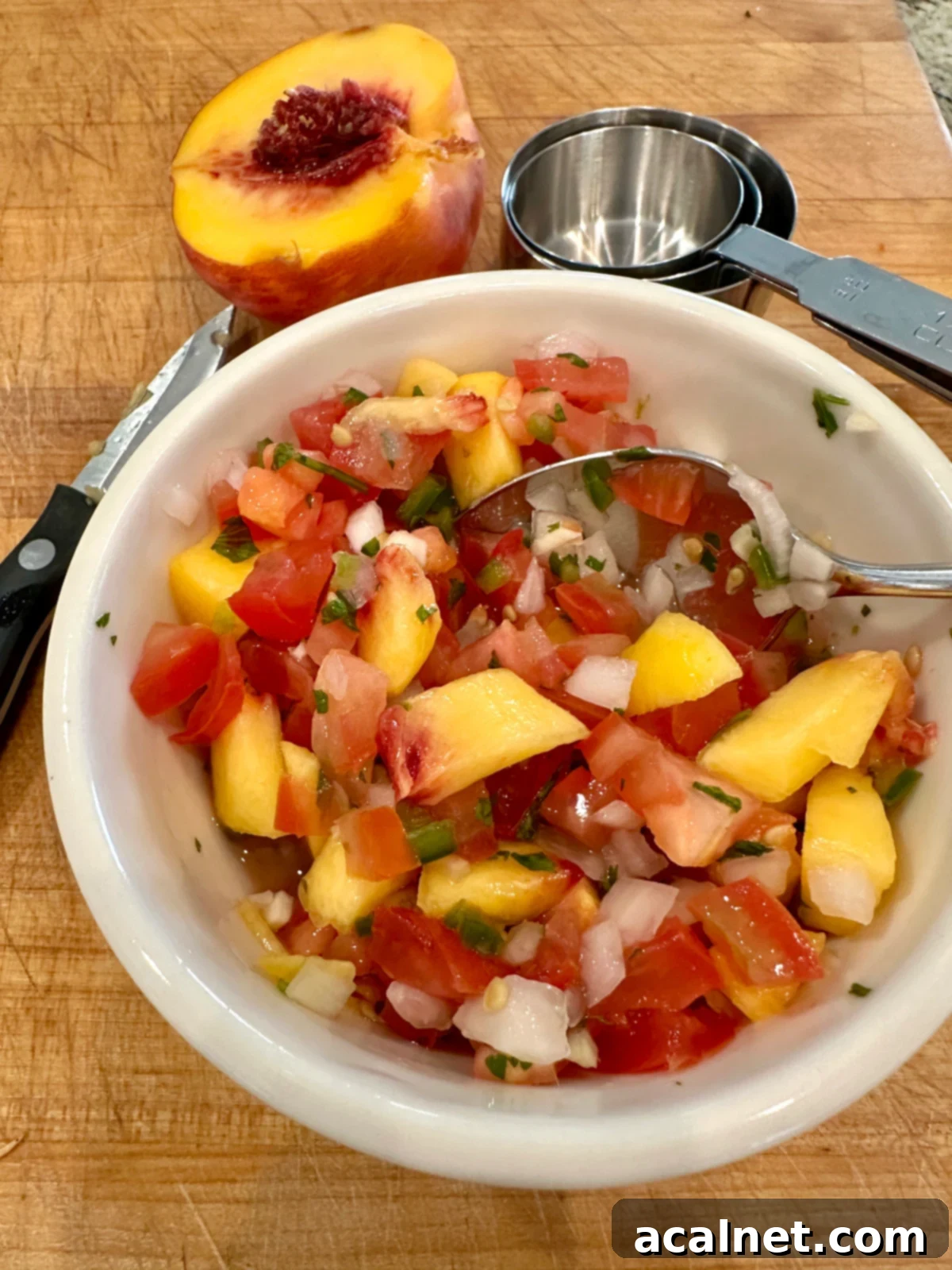 Zesty Jalapeño-Lime Pico de Gallo 6 A serving bowl of fresh pico de gallo enhanced with sweet, diced peaches, offering a delightful fruity twist.