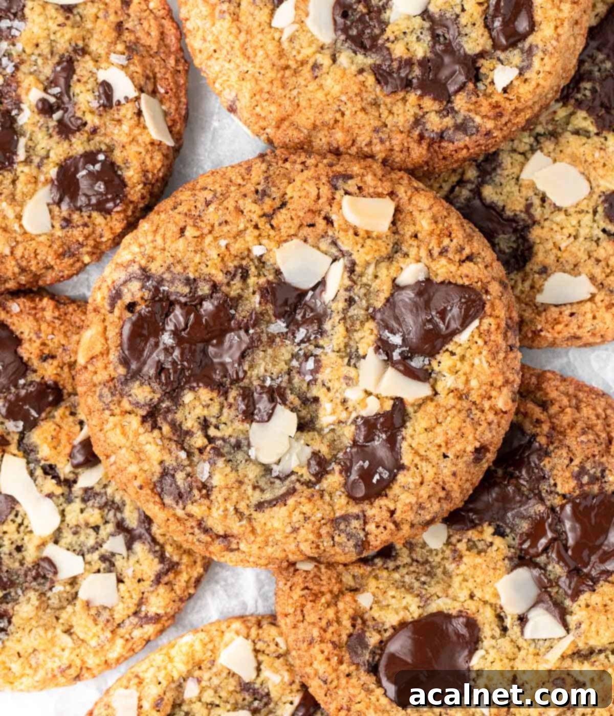 A top-down view of a stack of golden-brown chocolate chip almond cookies, showing their even spread and delicious appearance.