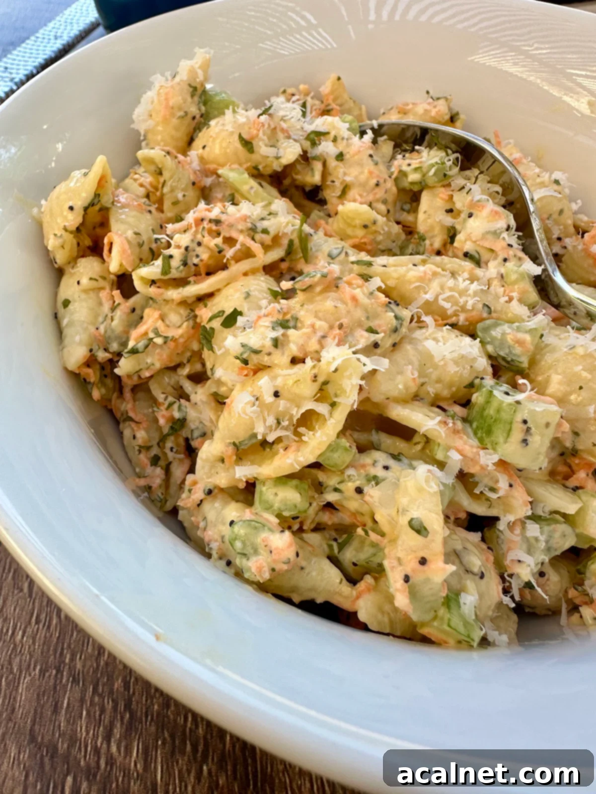 A bowl of pasta salad with a spoon.