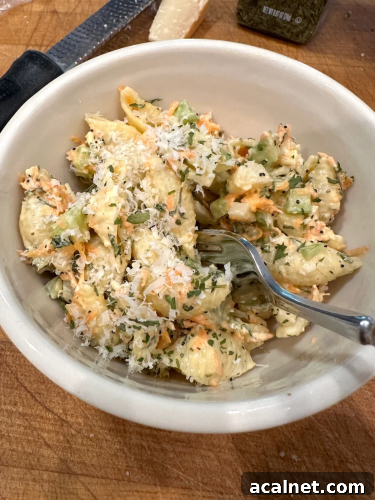 Pasta salad with salad dressing in a bowl with a fork.