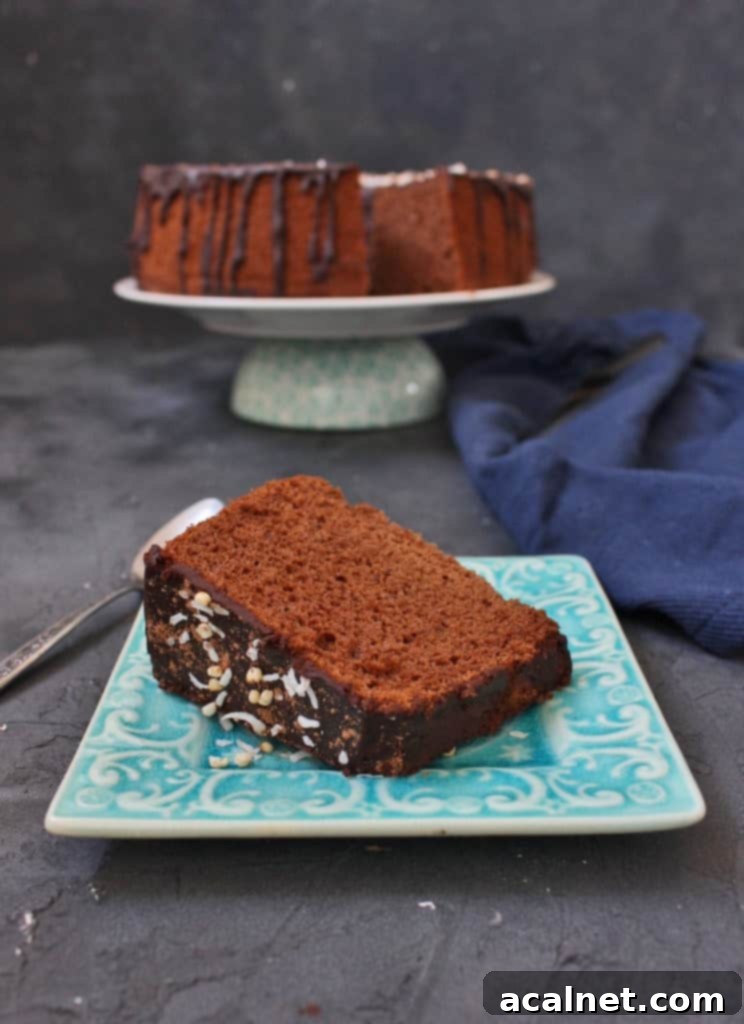 A single, perfectly cut slice of Chocolate Chiffon Cake topped with Coffee Chocolate Ganache, artfully presented on a blue plate, highlighting its layers and moist crumb.