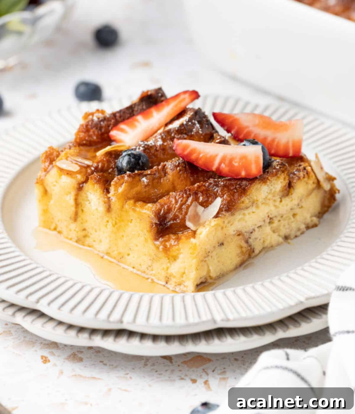 Brioche French Toast Bake 8 One perfect slice of golden brioche French toast on a small white plate, ready to be enjoyed.