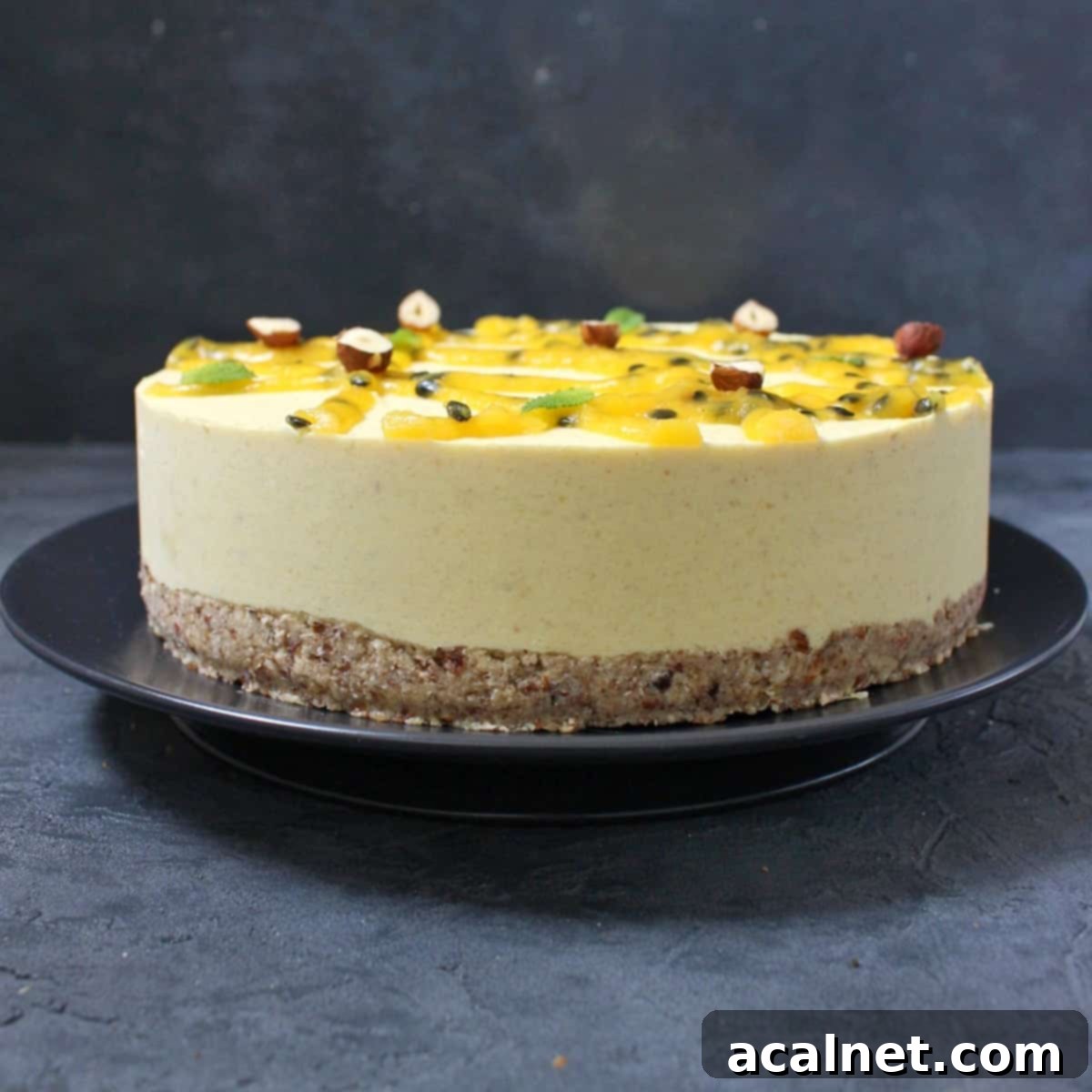 Vegan No-Bake Mango Cheesecake 2 Cheesecake on a black plate, showcasing its vibrant layers