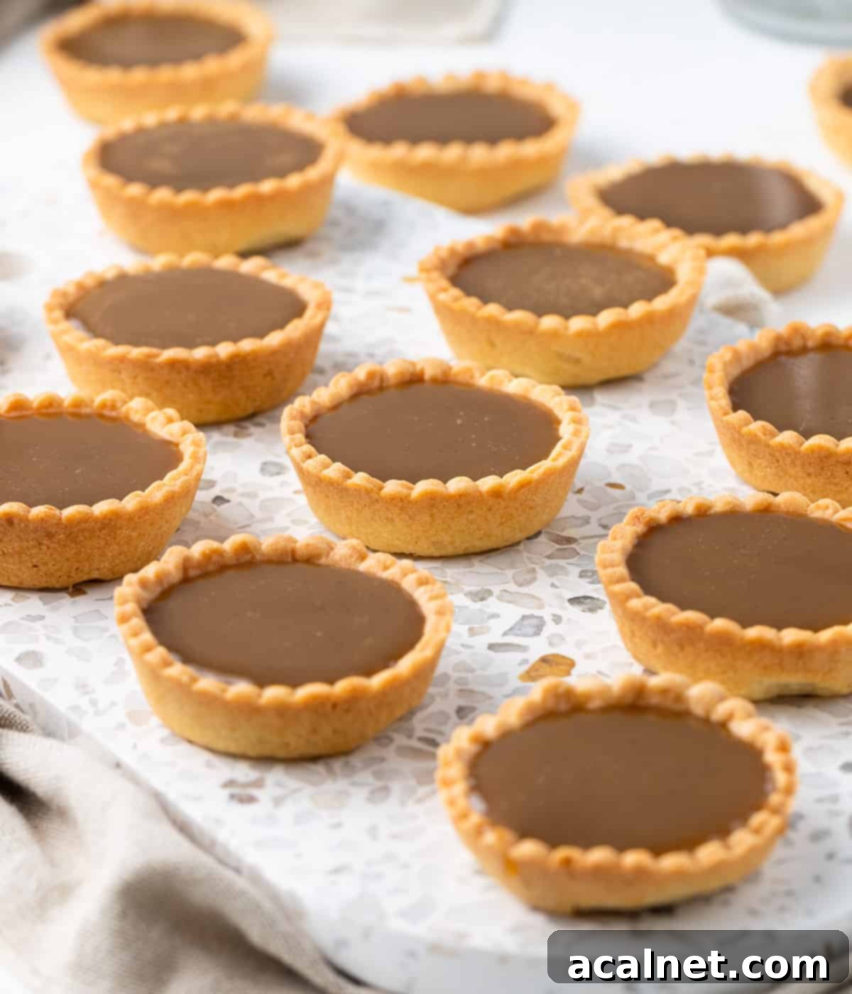 Mini Tarts on a white and grey stone tray, placed on a beige napkin.