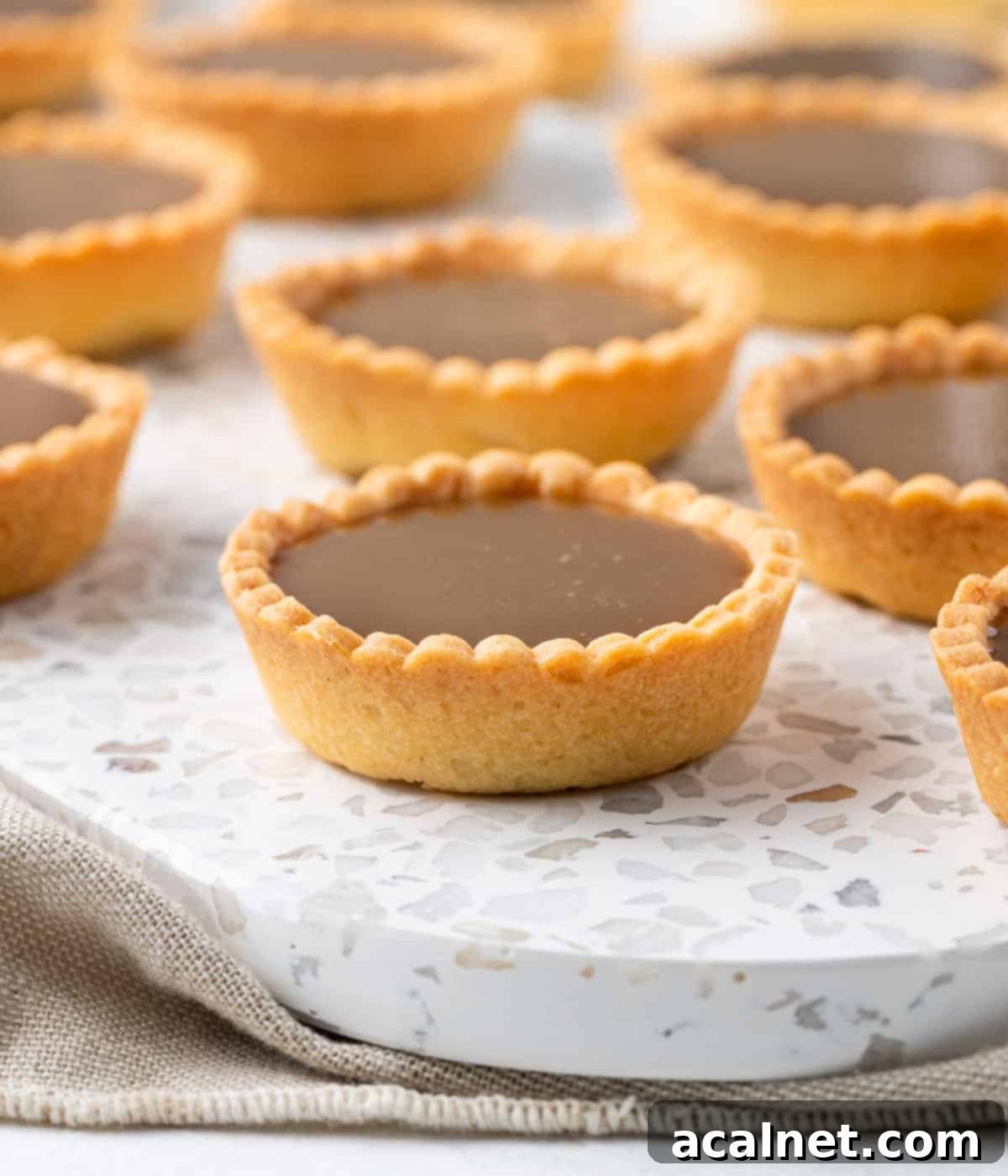 Close up on a tartlet over a speckled serving tray.