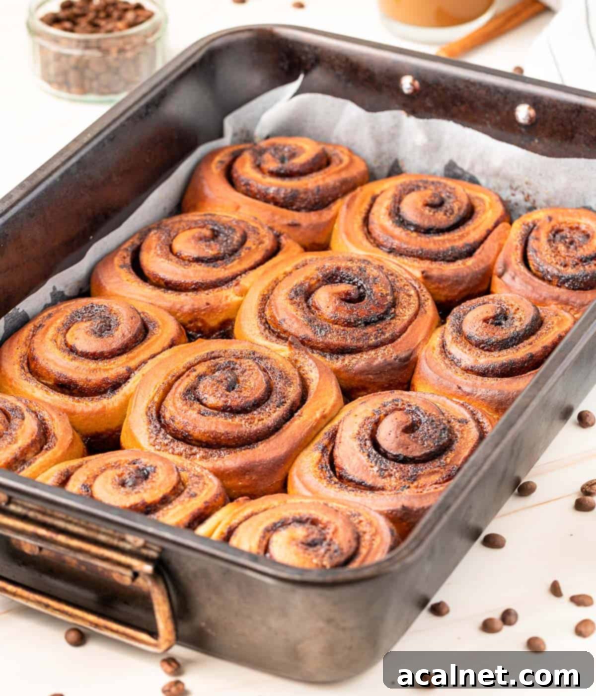 Close up on the baked coffee cinnamon rolls inside the metal baking tray, golden and inviting.