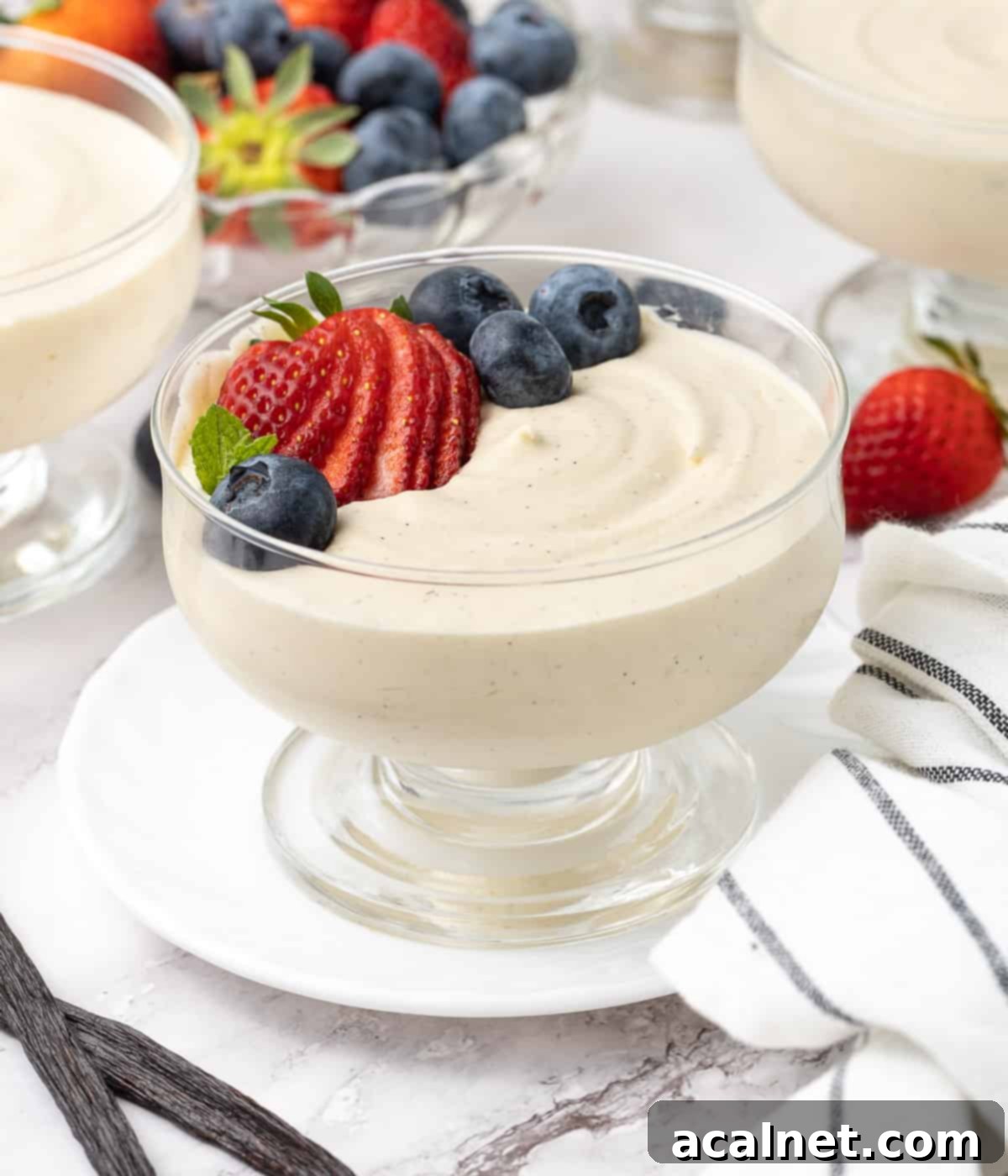 Effortless Vanilla Mousse Delights 8 Mousse topped with fresh berries placed over a small white plate.