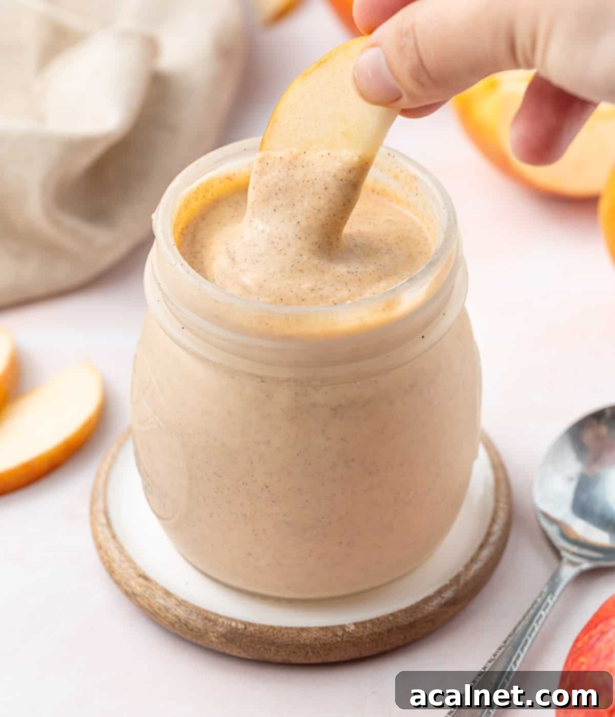 Dipping a slice of apple in the curd jar.