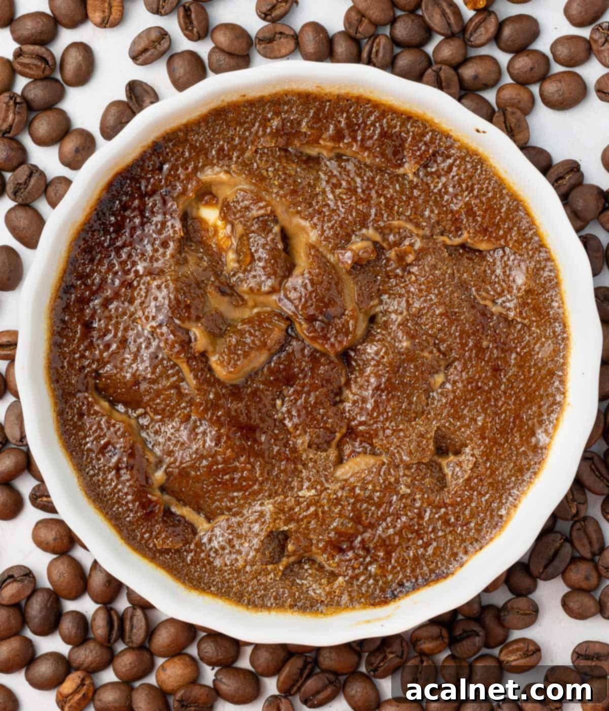 Creme brulee seen from above with the caramelised shell cracked.