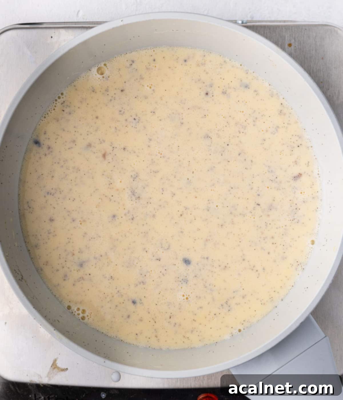 Cooked custard in a grey saucepan seen from above.