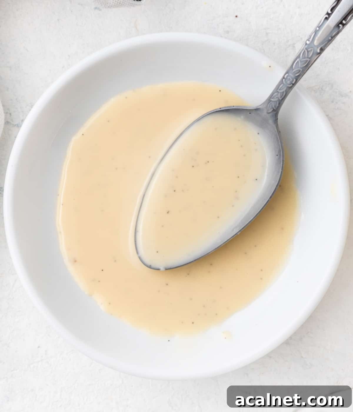 Cream in a small white bowl with a silver spoon.