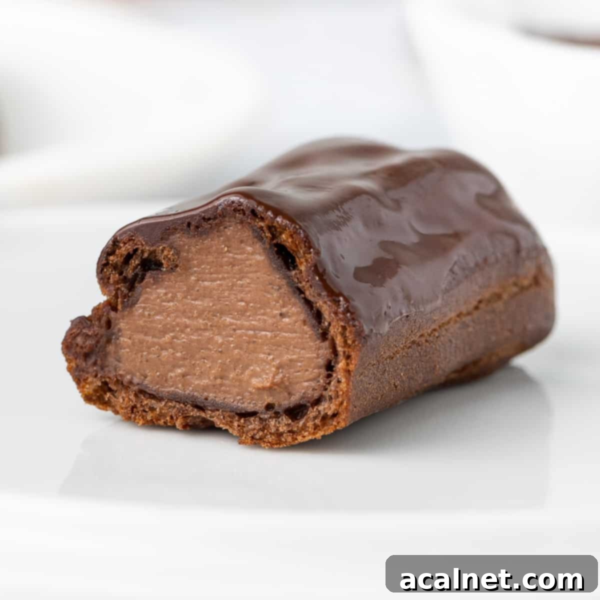 Eclair sliced in half showing the chocolate custard filling inside.