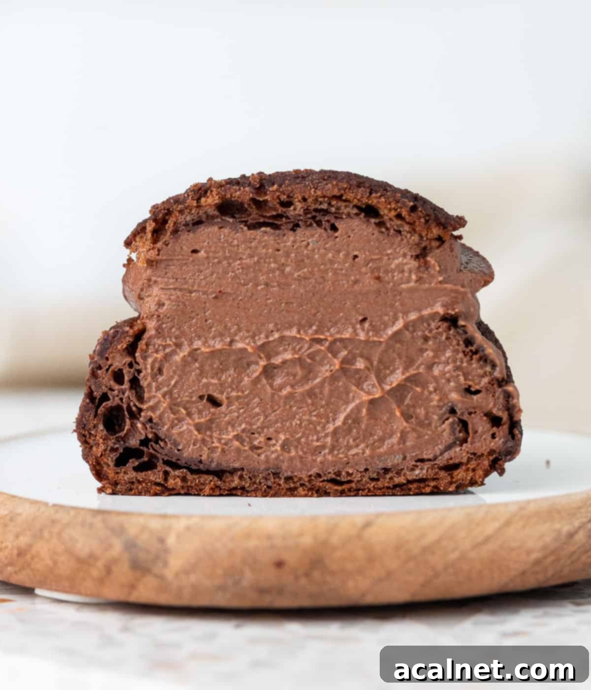 Choux sliced in half showing the chocolate custard filling inside.