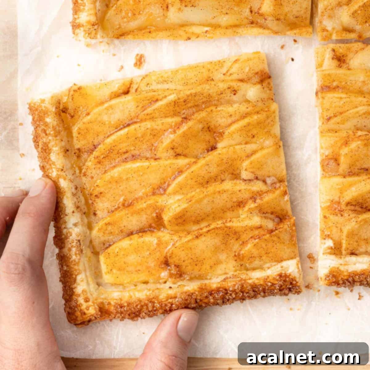 A hand picking up one slice from a cutting board