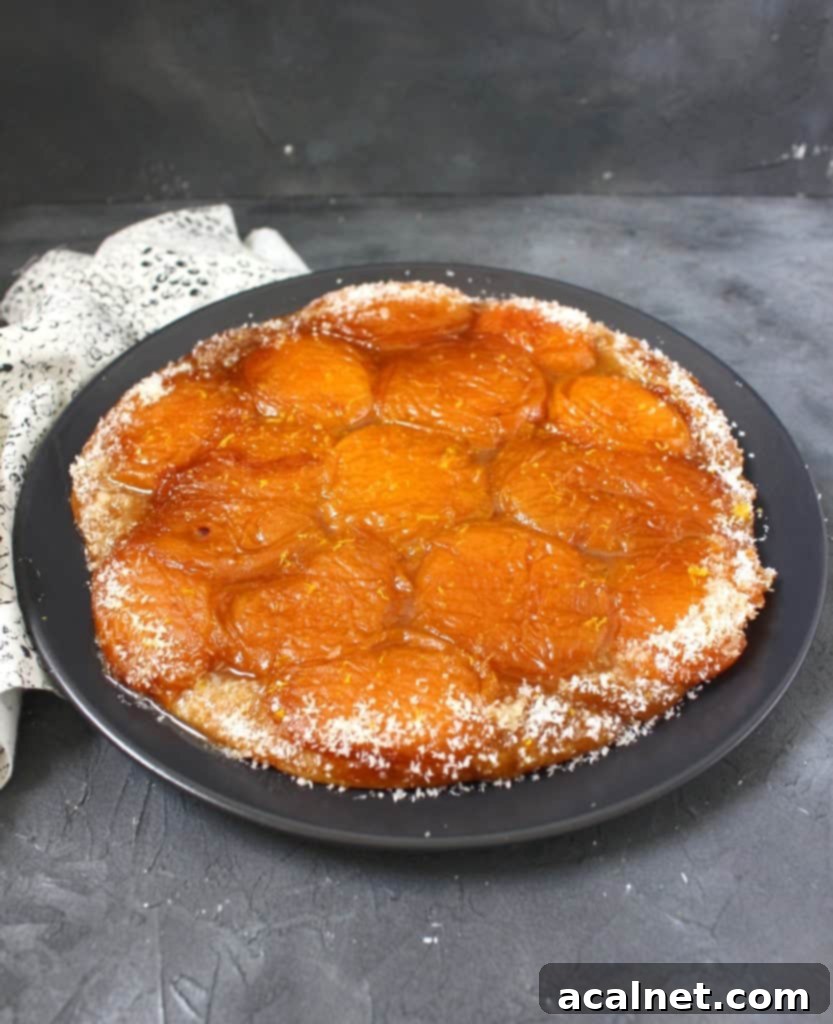 Tarte Tatin on a black plate, with a slice removed