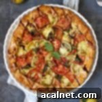 Tomato galette from above on a white stand with fresh basil