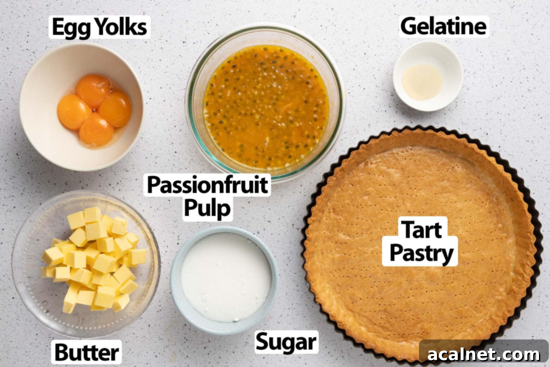 A curated selection of fresh ingredients neatly arranged on a light speckled surface, ready for preparing a delicious passion fruit tart. This image showcases the quality and freshness of the components used in the recipe.
