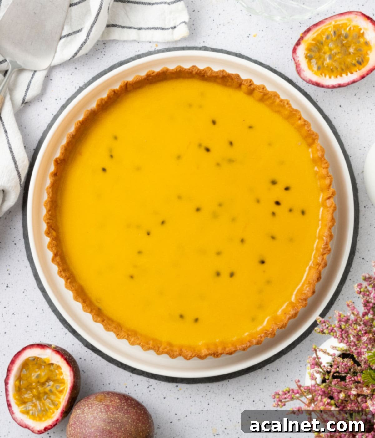 The perfectly set, vibrant passion fruit filling within a golden tart shell, viewed from directly above. The smooth surface indicates a well-prepared crémeux, ready for an optional topping.