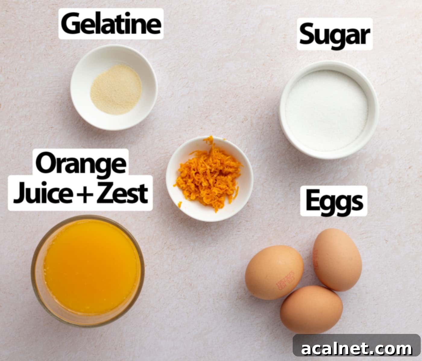 Zesty Orange Mousse Cups 3 Ingredients laid on a light orange surface seen from above.