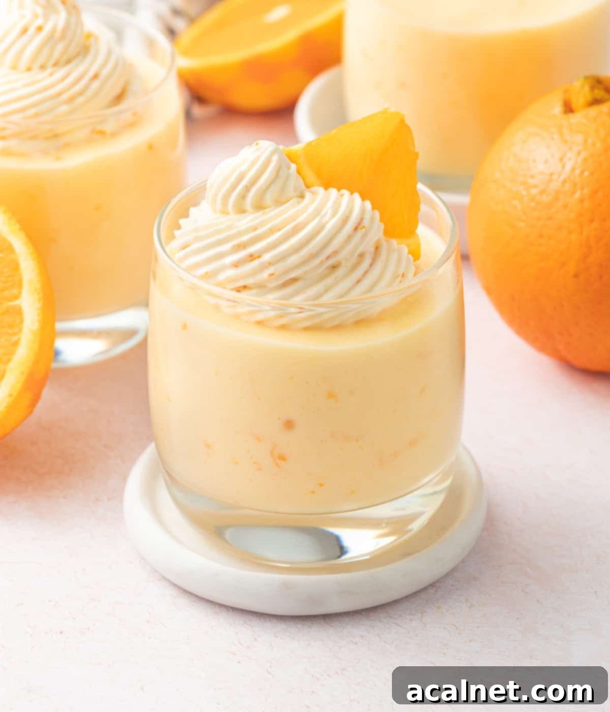 Zesty Orange Mousse Cups 9 One cup of mousse with oranges and two other cups in the background.