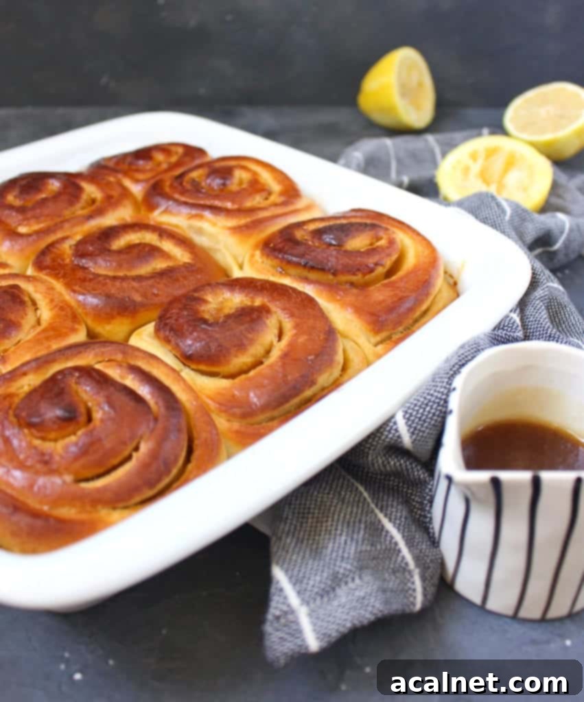 Freshly baked Lemon Sweet Rolls in a white ceramic dish, slightly golden brown.