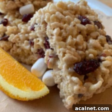 Rice Krispie treats stacked with a wedge of orange on the side.