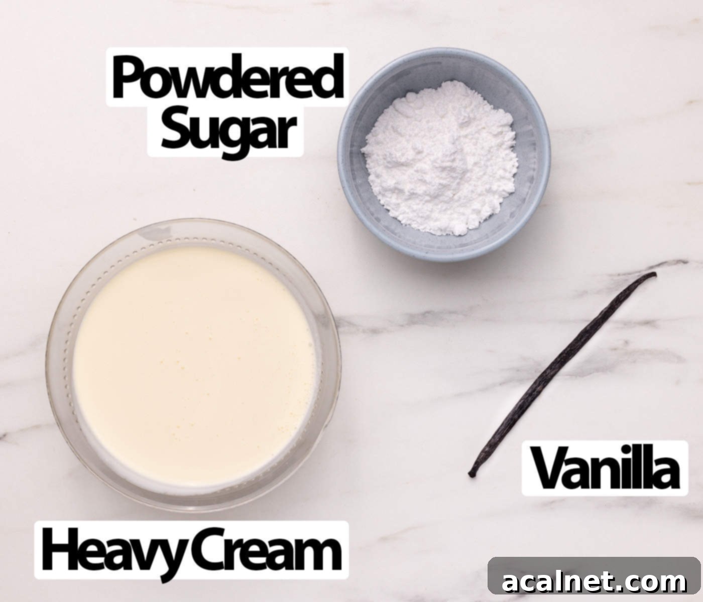 Ingredients for Chantilly Cream laid out on a light grey surface, including heavy cream, powdered sugar, and a vanilla bean.