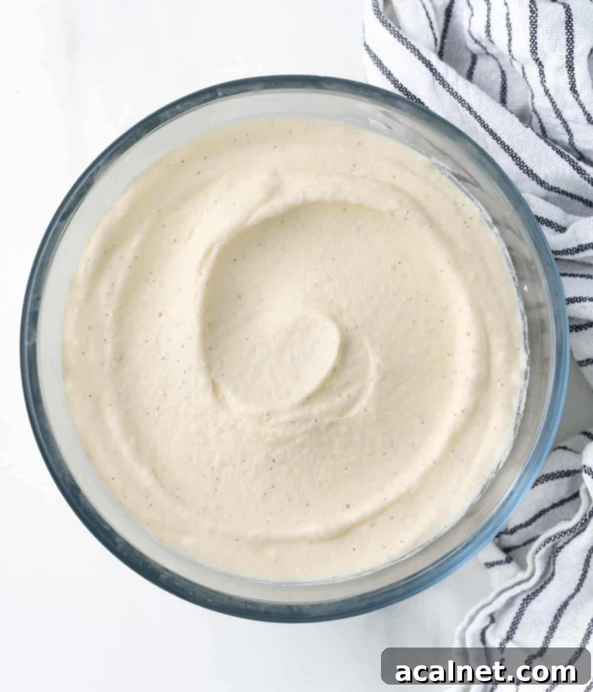 Cream spread in a glass mixing bowl seen from above, showcasing the smooth consistency of finished Chantilly Cream.
