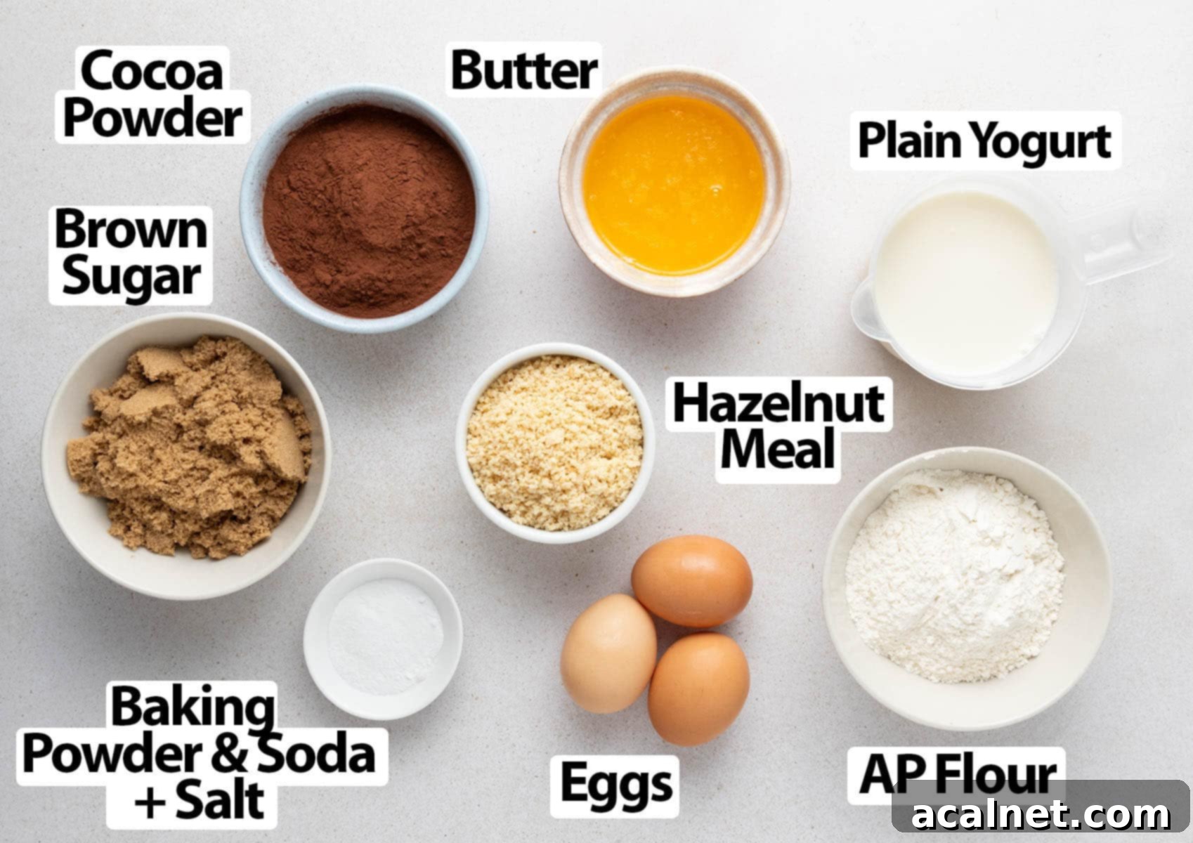 Simple Chocolate Hazelnut Delight 3 A curated display of all the essential ingredients laid out neatly on a light grey surface, ready for baking this delicious chocolate hazelnut cake.