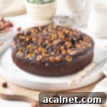 Simple Chocolate Hazelnut Delight 10 Cake on a large white plate placed over a wooden cutting board.