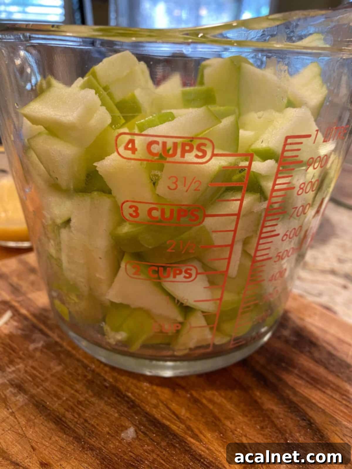Diced apples in a glass measure cups.