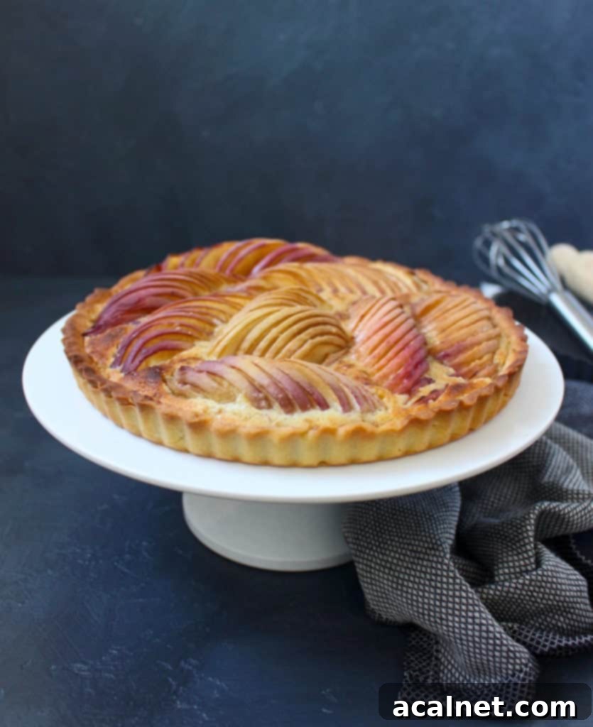 Peach Tart on a white cake stand with a grey napkin below.
