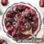 Picking up some compote from a glass bowl with a spoon, seen from above.